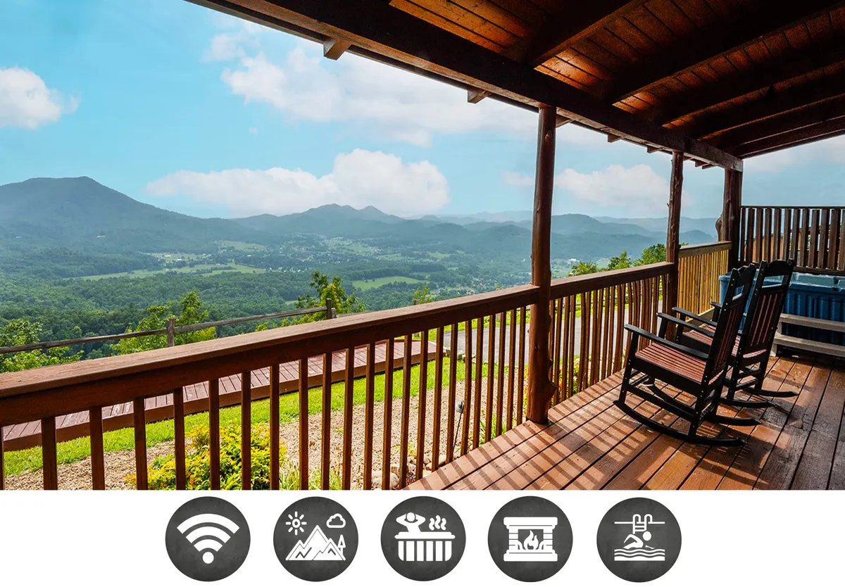 The image showcases a peaceful wooden deck framed by classic rocking chairs and a bubbling hot tub, all overlooking a breathtaking expanse of Smoky Mountain ridgelines beneath an open sky. The warm wooden railing and lush treetop views invite guests to relax, soak in the scenery, and savor the tranquility of nature.